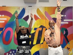 Ms. Victoria and Reginald Brown with arms outstretched and energizing the audience.